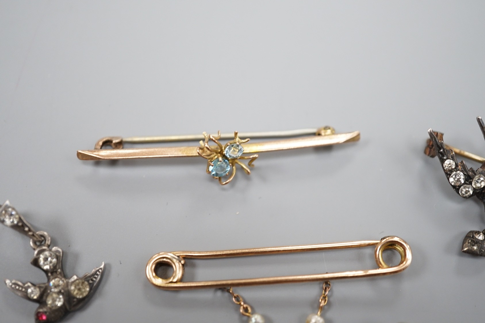 A modern 9ct gold and opal set bug brooch, 24mm, a paste set white metal swallow pendant and similar brooch and two yellow metal bar brooches, one with gem set spider, the other with baroque pearl drop.